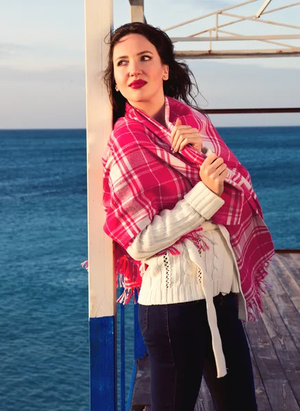 Atrakcyjny dziewczynka stojący w pobliżu morza zawinięte w koc — Zdjęcie stockowe