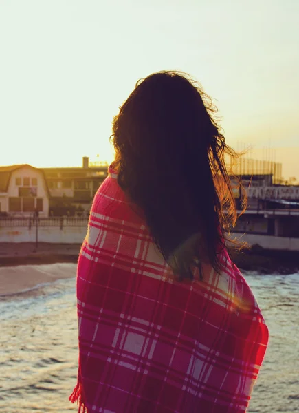 Çekici kız bir battaniyeye sarılmış deniz kenarında ayakta Stok Resim