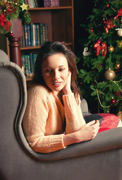 Portret van een jonge vrouw in de buurt van de kerstboom — Stockfoto