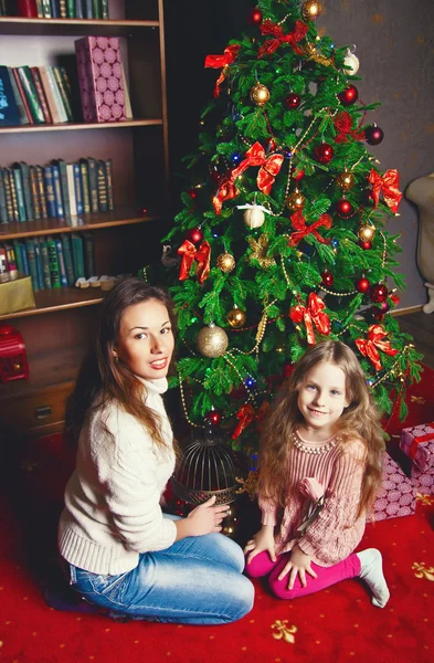 Junge Mutter mit Baby in der Nähe des Weihnachtsbaums — Stockfoto