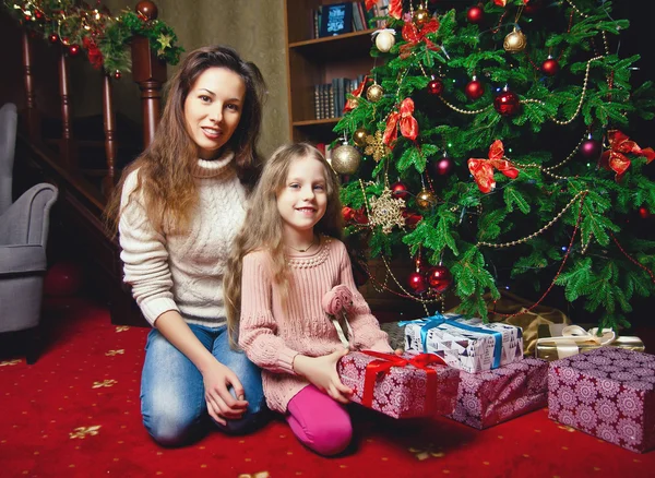 Madre joven con bebé cerca del árbol de Navidad — Foto de Stock