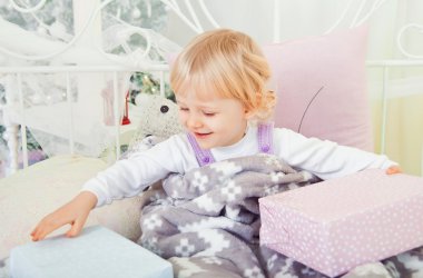 sevimli küçük kız yatakta Noel hediyesi ile
