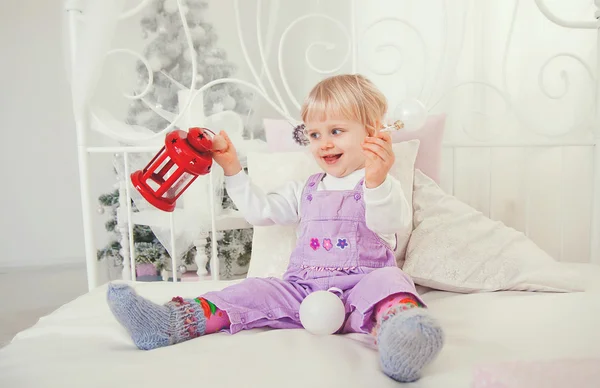 Sevimli küçük kız yatakta Noel hediyesi ile — Stok fotoğraf