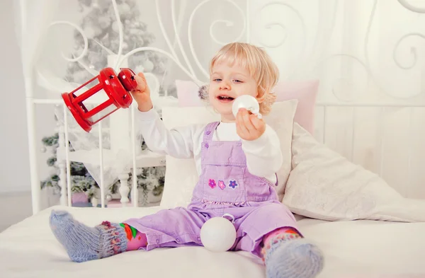 Sevimli küçük kız yatakta Noel hediyesi ile — Stok fotoğraf