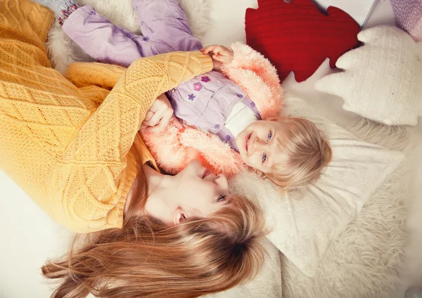 Young mother and baby lying on the floor view from above — Stock Photo, Image