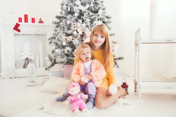 Young mother with baby near Christmas tree — Stock Photo, Image