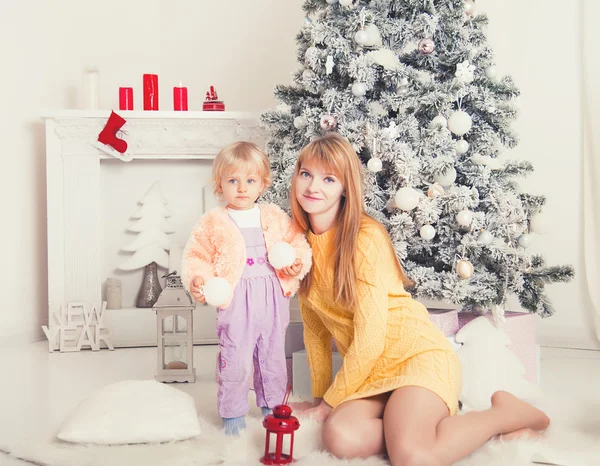 Jonge moeder met baby in de buurt van de kerstboom — Stockfoto