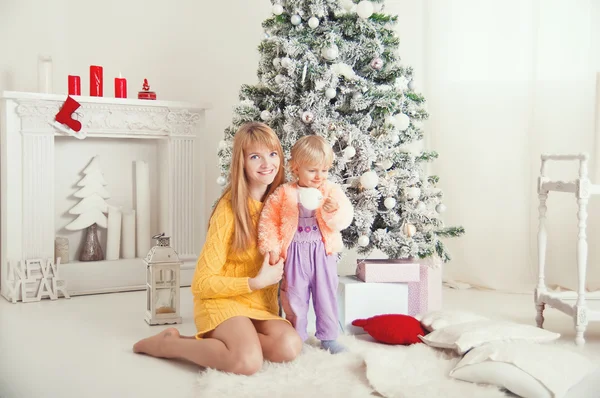 Young mother with baby near Christmas tree — Stock Photo, Image