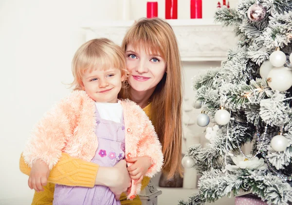 Madre joven con bebé cerca del árbol de Navidad —  Fotos de Stock