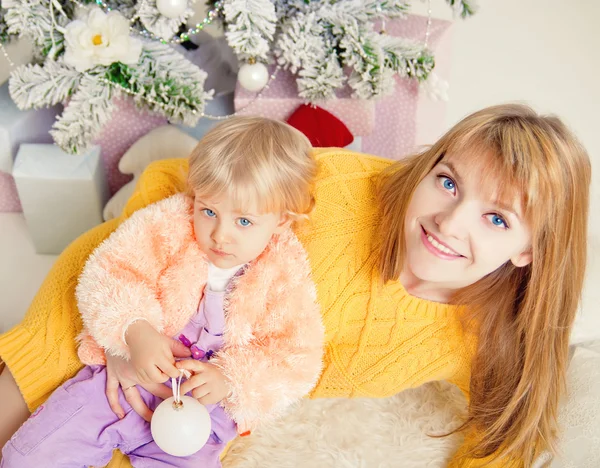 Junge Mutter mit Baby in der Nähe des Weihnachtsbaums — Stockfoto