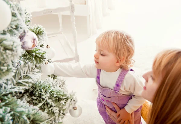 Young mother with baby near Christmas tree — Stock Photo, Image