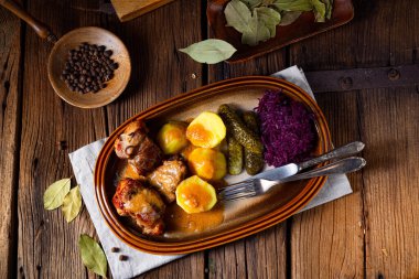 Rustic Snirtjebraten with red cabbage and cucumber clipart