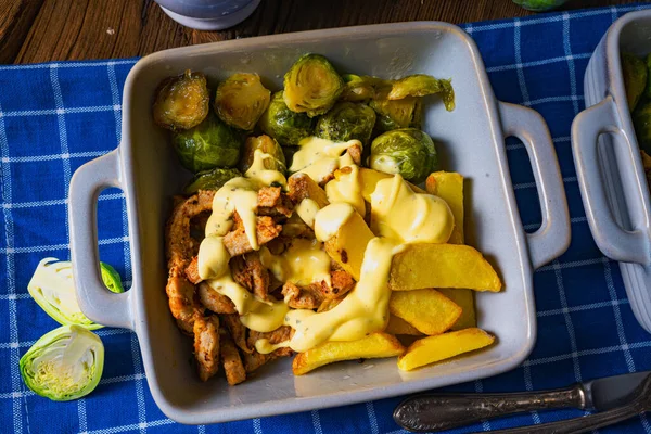 Gratinated Zurich ragout with Brussels sprouts, potatoes and Bearnaise sauce