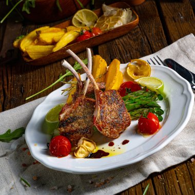 Yeşil kuşkonmaz ve limonla marine edilmiş kuzu pirzolası.