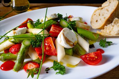 Çilekli kuşkonmaz salatası, domates ve keçi peyniri.