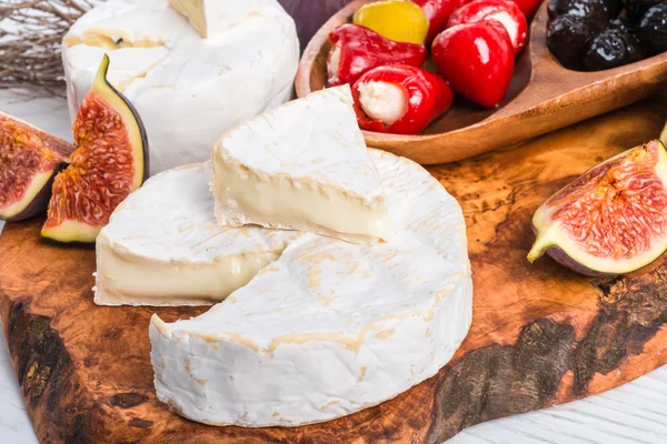 Brie ost och fikon på träskiva — Stockfoto