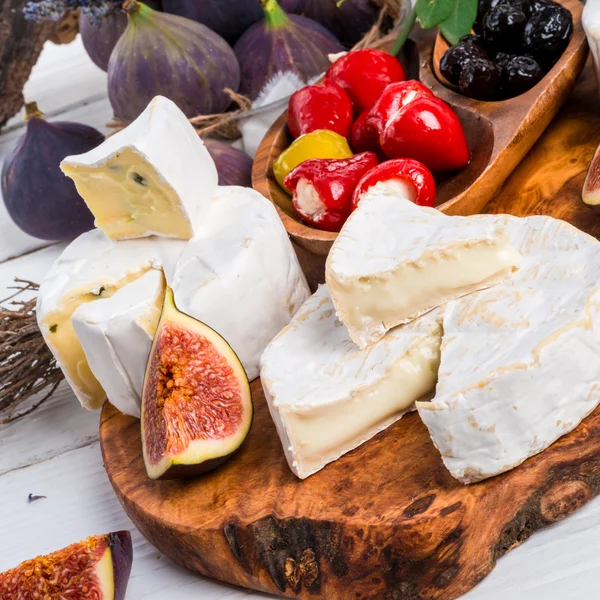 Queso Brie e higos sobre tabla de madera —  Fotos de Stock