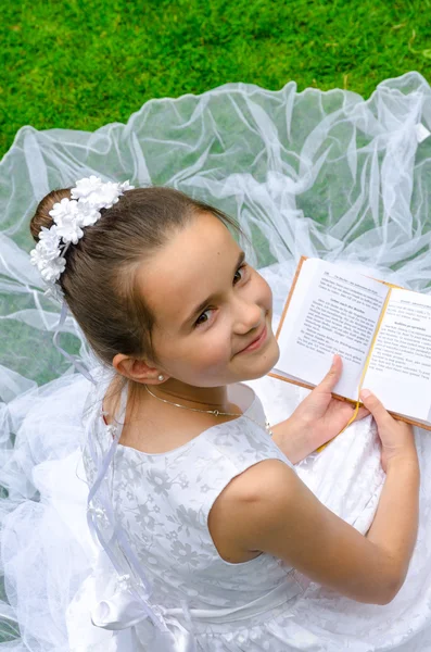 Menina lendo Primeira Santa Comunhão — Fotografia de Stock