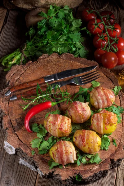 Baked potatoes wrapped in ham — Stock Photo, Image