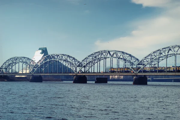 Demiryolu köprüsü üzerinde erken ilkbaharda Riga'da tren. — Stok fotoğraf