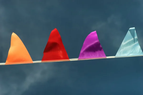 Colored triangular flags against the sky in the wind — Stock Photo, Image