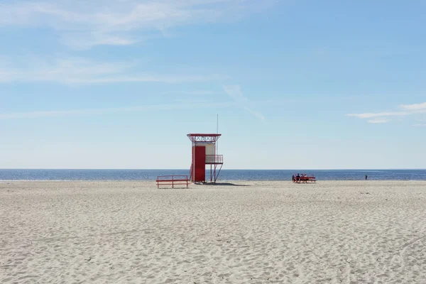 Відпочиваючі люди про рятувальну станцію на пляжі — стокове фото