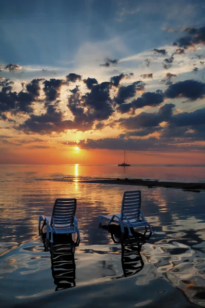 Due sedie a sdraio vuote con ombra in acqua la spiaggia ai soli — Foto Stock