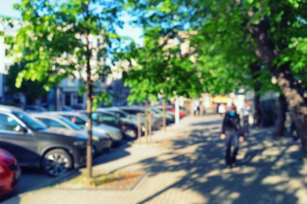 Аллея с деревьями и припаркованная машина в солнечный день. Blurry — стоковое фото