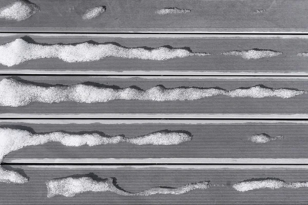 Snow melts in the spring striped boards — Stock Photo, Image