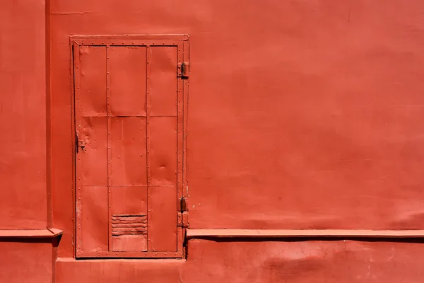 Porta de metal vermelho na parede pintada — Fotografia de Stock
