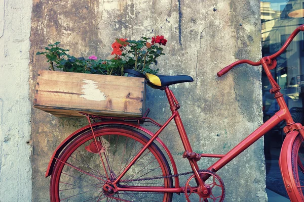 Flores en una bicicleta roja cerca de la pared — Foto de Stock