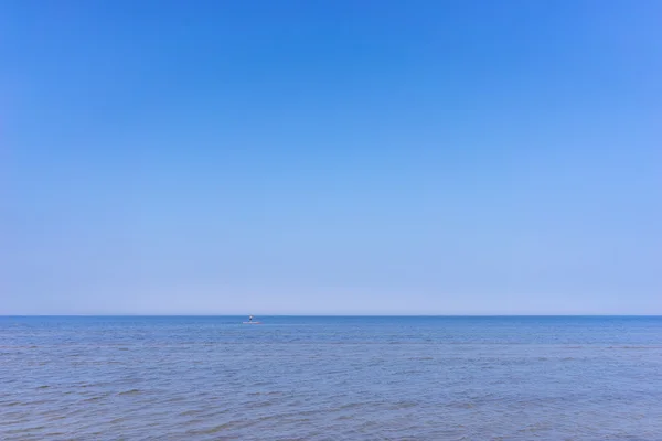 Ein Mann mit einem Ruder auf dem Brett im Meer — Stockfoto