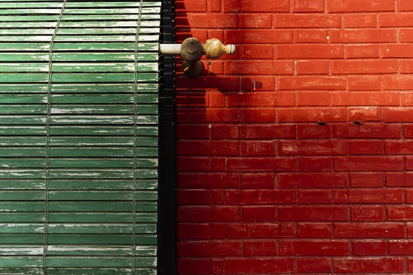 Groene houten jaloezieën en rode bakstenen muur — Stockfoto