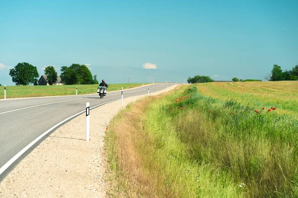 Strada asfaltata tra i campi agricoli della Lettonia — Foto Stock