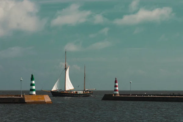 Zeilboot passeert de vuurtorens in de haven van Nida — Stockfoto