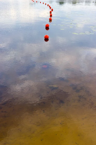 Superficie de un lago con bolas rojas — Foto de Stock