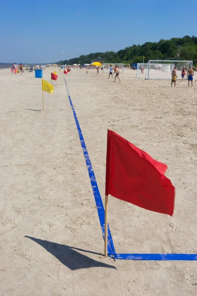 Rote Fahne auf dem Fußballplatz am Strand — Stockfoto