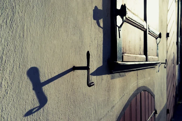 Window with shutters on a white wall with shadows — Stock Photo, Image