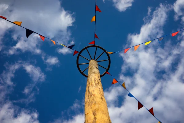 Pole wheel and colored flags on sky background — Stock Photo, Image