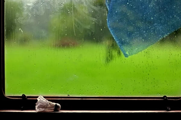 Badminton shuttlecock and a blue curtain at the window in the ra — Stock Photo, Image