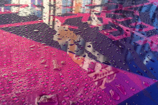 Reflexão da cidade em plástico colorido com gotas de chuva — Fotografia de Stock