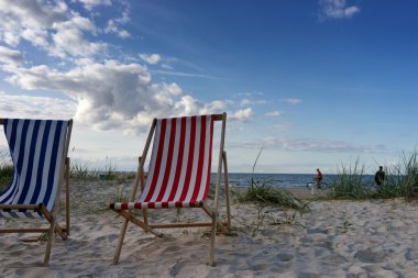 Mavi ve kırmızı sandalye yaz aylarında sahilde