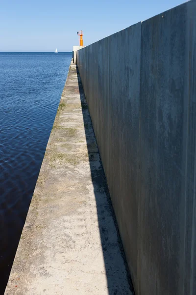 Denizin beyaz yelken ve deniz feneri ile beton cape — Stok fotoğraf