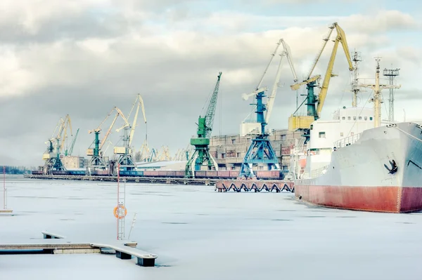 O navio está em guindastes portuários em um fundo de inverno — Fotografia de Stock