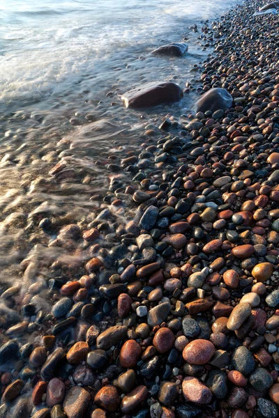 Olas en la playa de piedras redondas — Foto de Stock