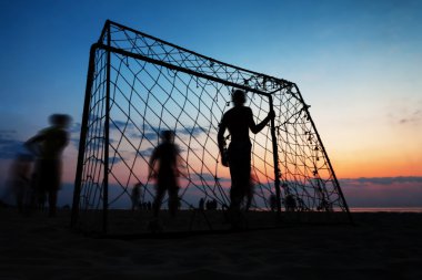 Yaz aylarında sahilde futbol oynayan çocuklar