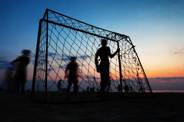 เด็กชายเล่นฟุตบอลบนชายหาดในฤดูร้อน — ภาพถ่ายสต็อก