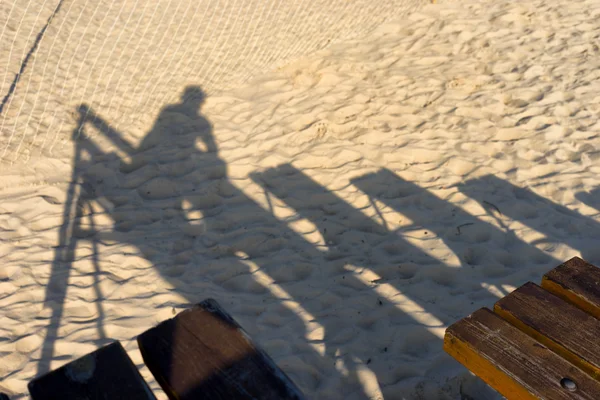 Görüntüleyiciyi net plajda bir bankta gölgesi — Stok fotoğraf