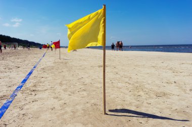 Sarı Bayrak ve kum Beach'te mavi çizgi