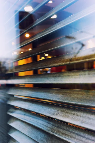 Die Stadt spiegelt sich im Fenster eines Cafés mit Rollläden — Stockfoto